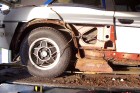 Rusted rear wheel arch and chassis exposed, with rusted remains lying on the ramp.